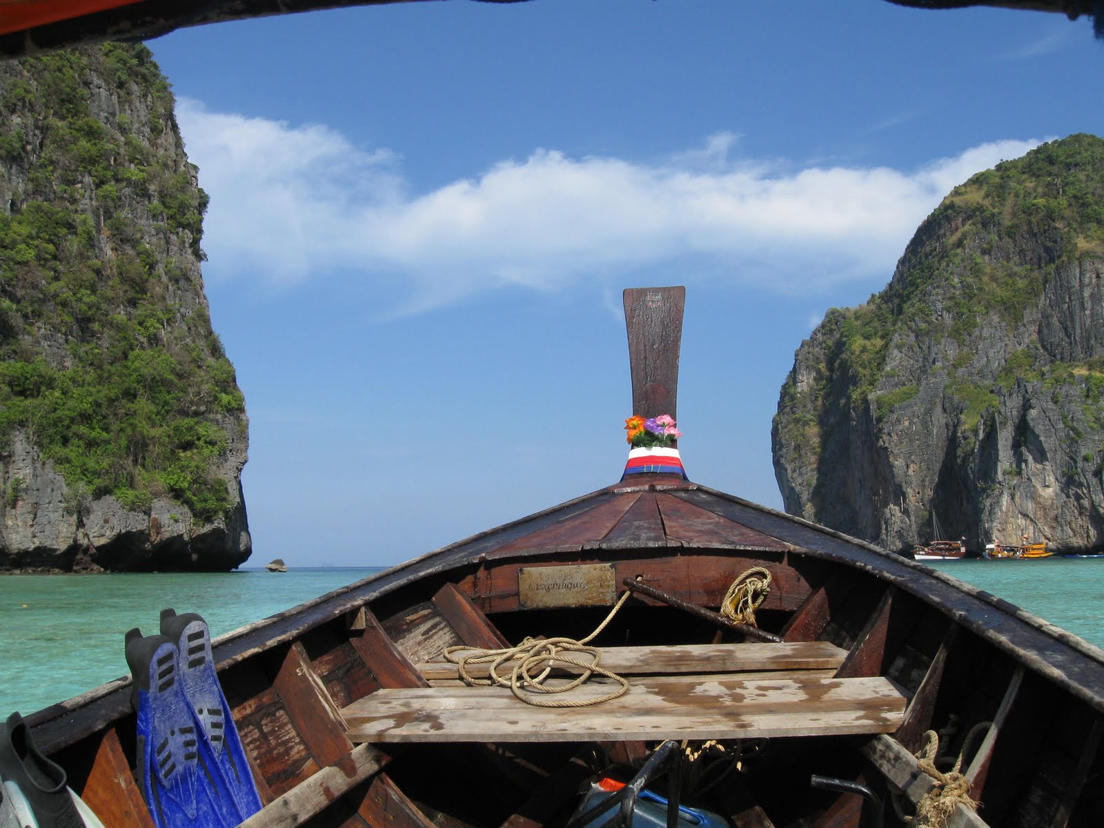 The bow of a longtail boat heading between limestone cliffs in the Phi Phi Islands
